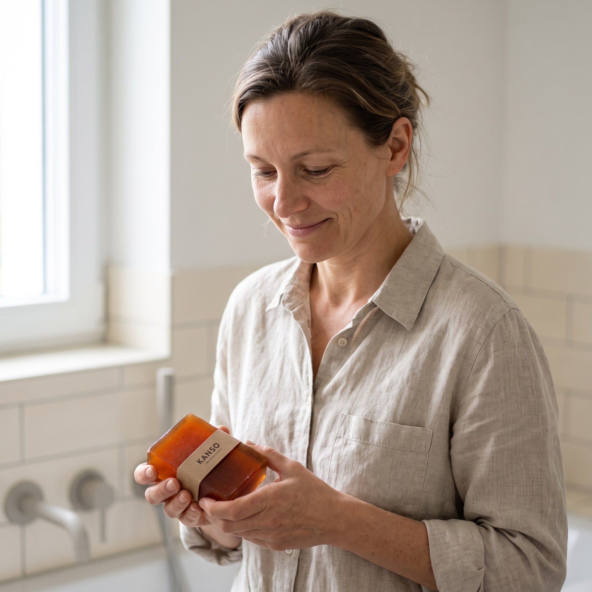 Frau hält die Persimmon Seife von Kanso Pflege